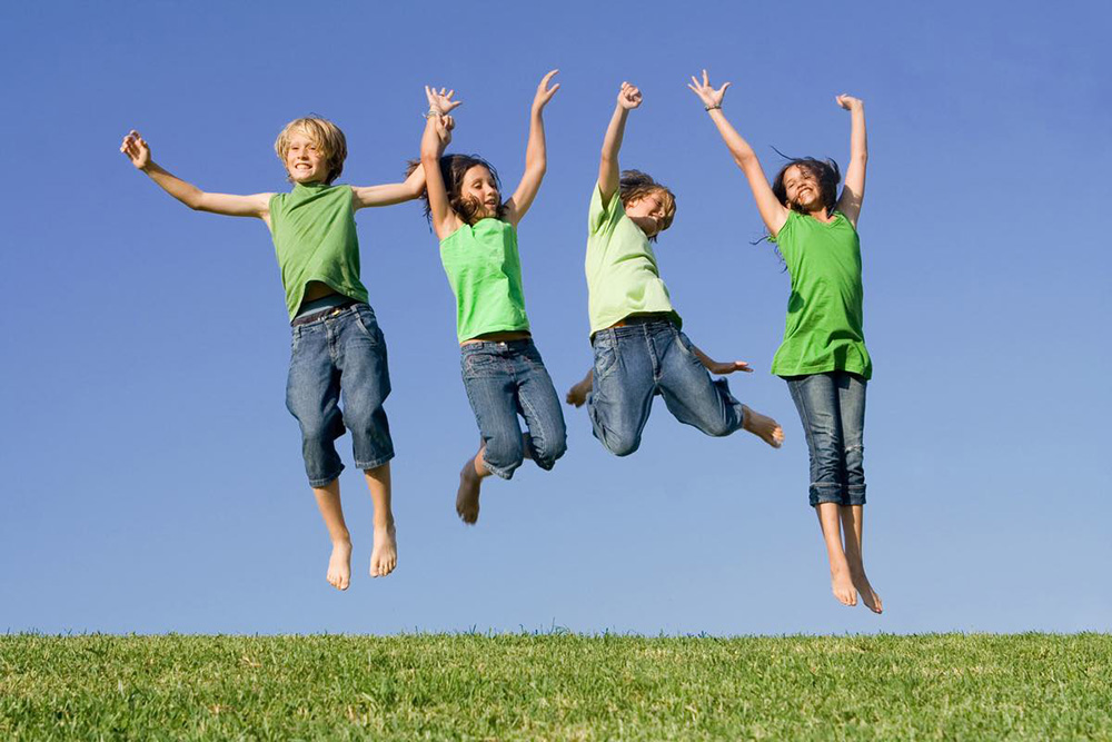children jumping in a field